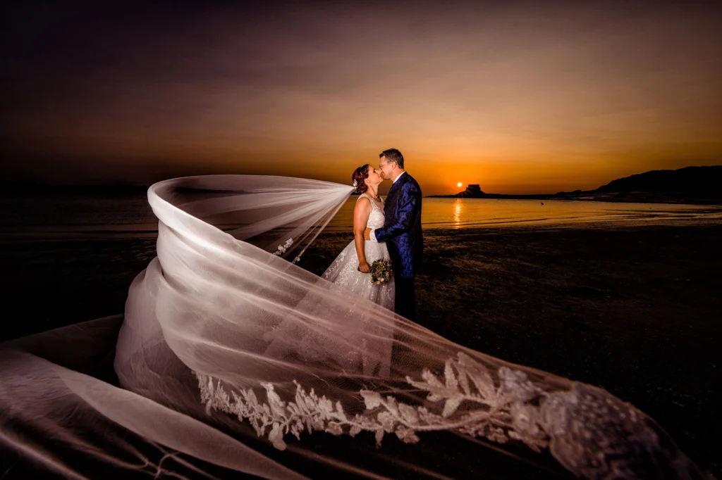Couple de mariés, en bord de mer, couché de soleil