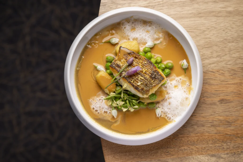Plat gastronomique dressé avec poisson, légumes et sauce, photographie culinaire professionnelle à Rennes