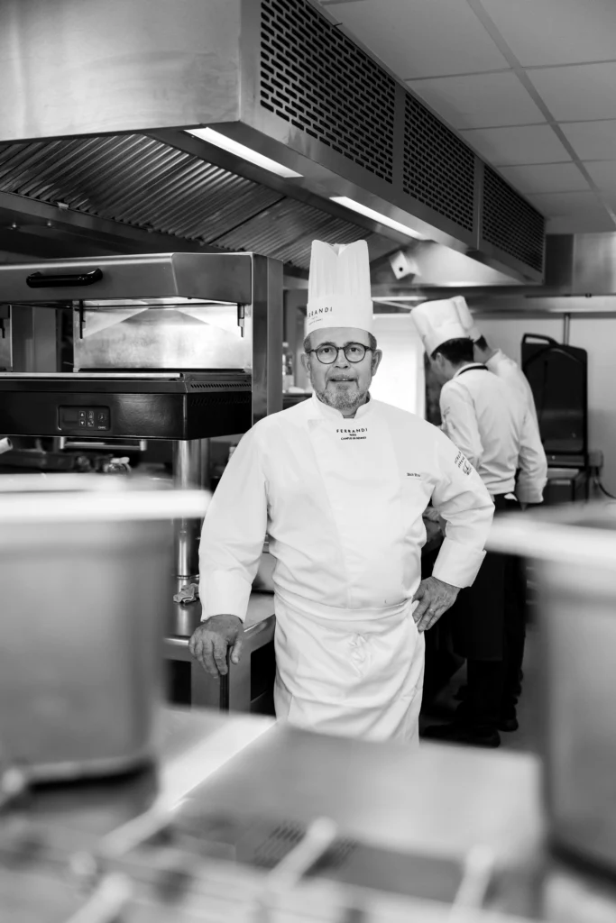 Chef cuisinier en tenue professionnelle dans une cuisine de restaurant, portrait noir et blanc